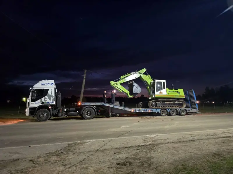 Camión con carretón de Hidra Dock trasladando una excavadora de noche