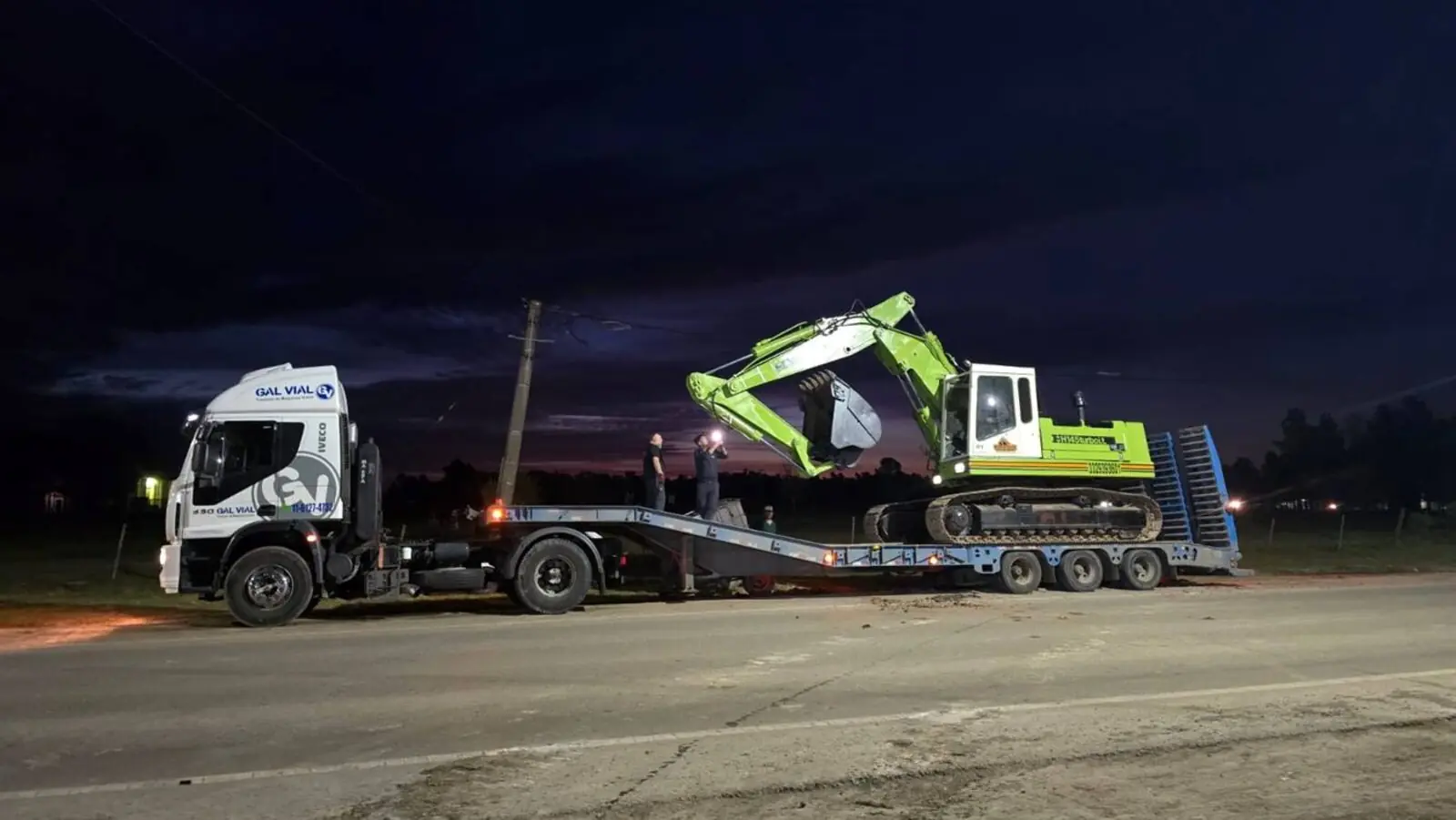 Camión con carretón de Hidra Dock trasladando una excavadora de noche